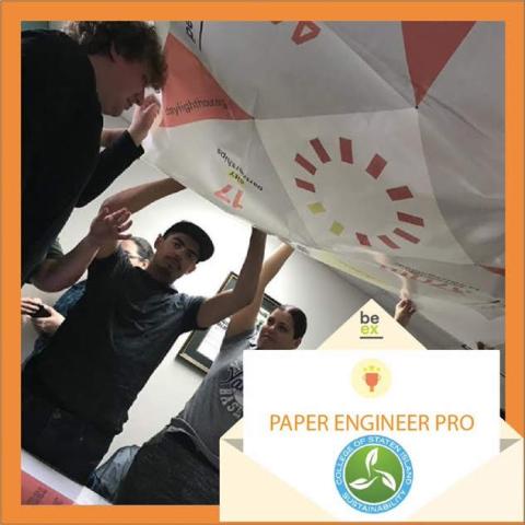 Paper Engineering Pro Award Students are holding up above their head the giant origami before they folded it together. 