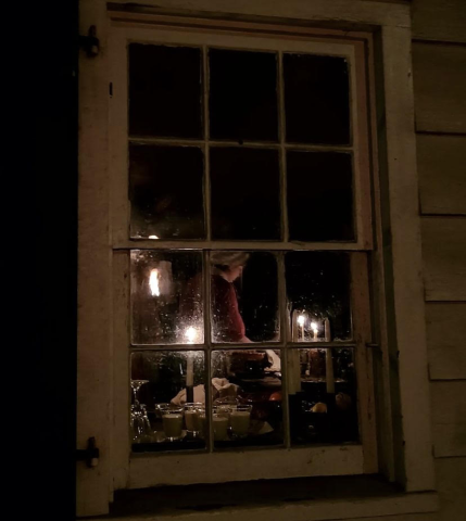A woman working by candle light in Historic Richmond Town A woman working by candle light in Historic Richmond Town