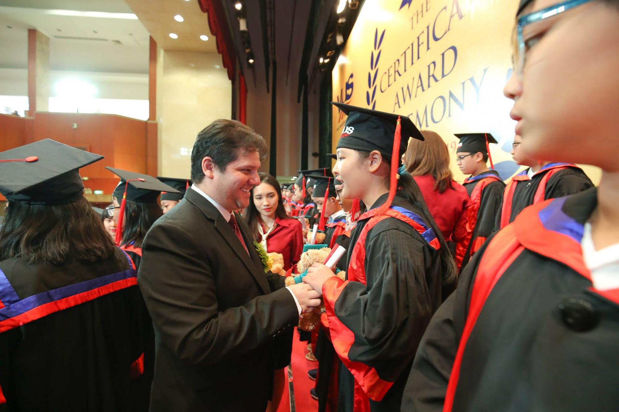 ELI Director giving diplomas and medals to VUS students during their graduation