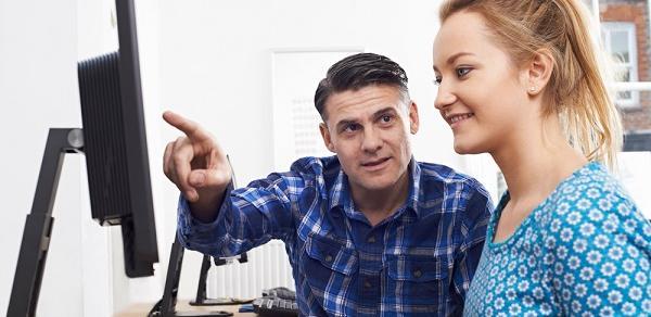 Instructor helping student on a computer